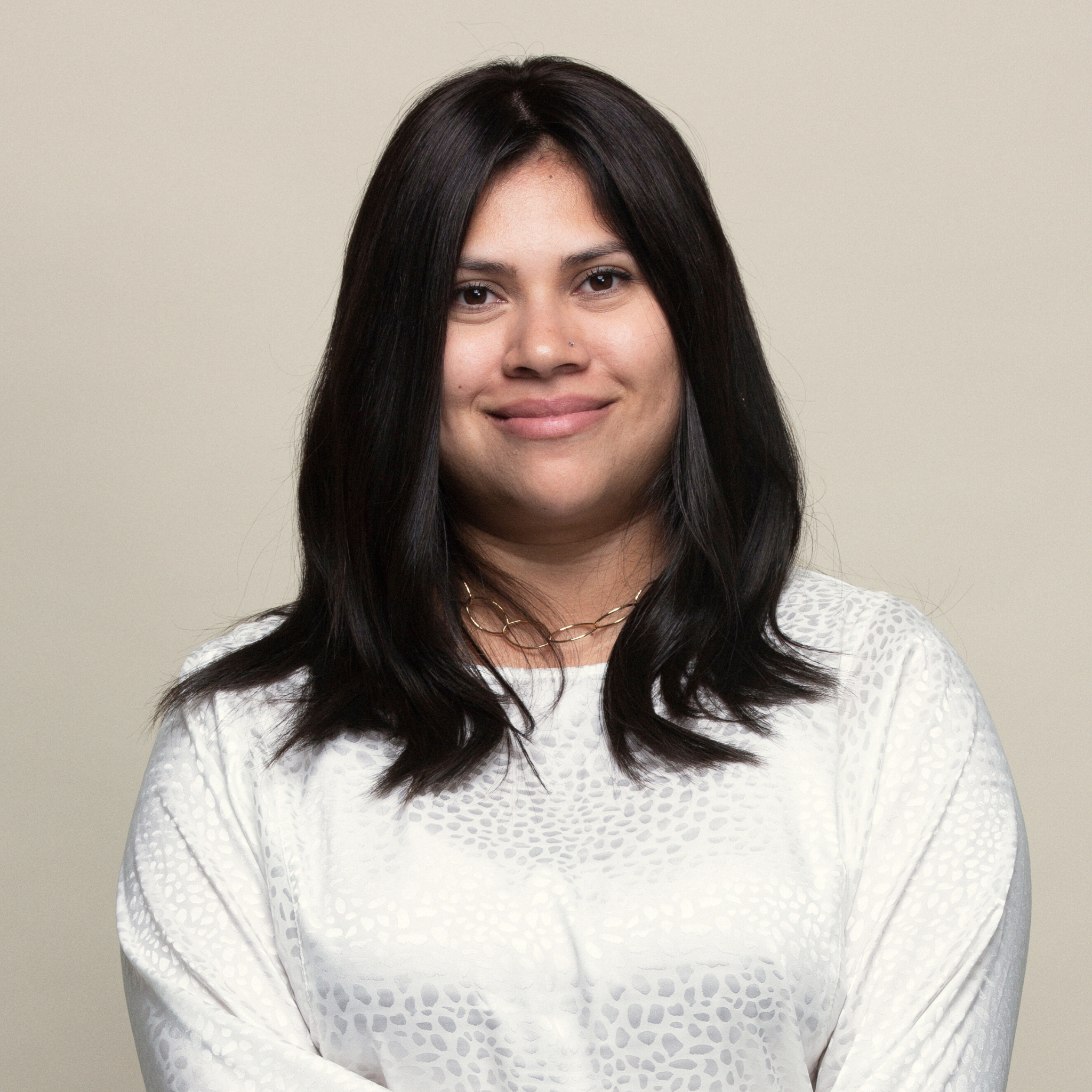 Woman displaying a synthetic hair topper, highlighting its seamless blend with her natural hair for added length and fullness.