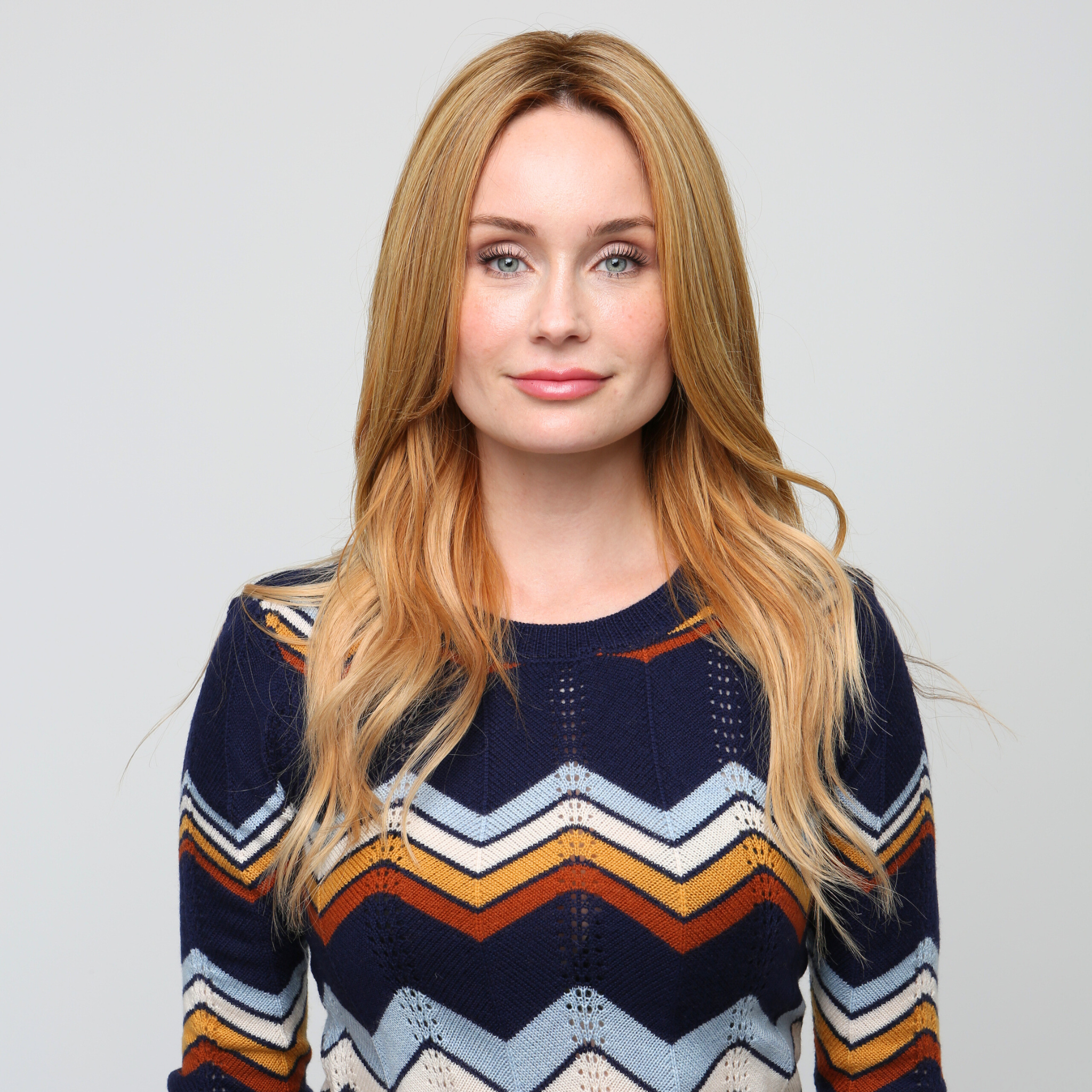 Woman wearing a synthetic hair topper, highlighting its seamless blend with her natural hair for added length and fullness.